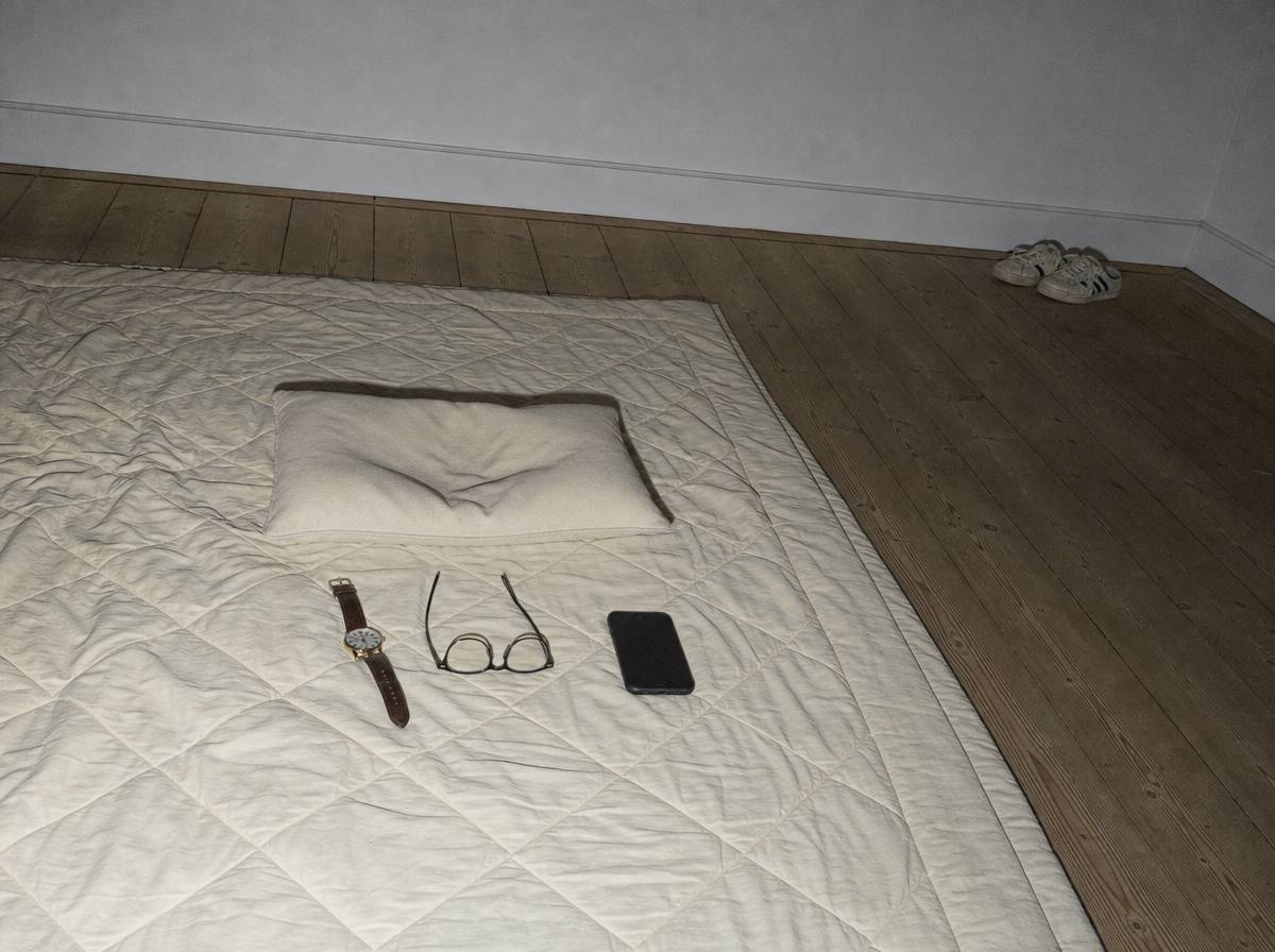 Koc, mała poduszka, zdjęty zegarek i telefon ekranem do podłogi przygotowane do sesji relaksacyjnej