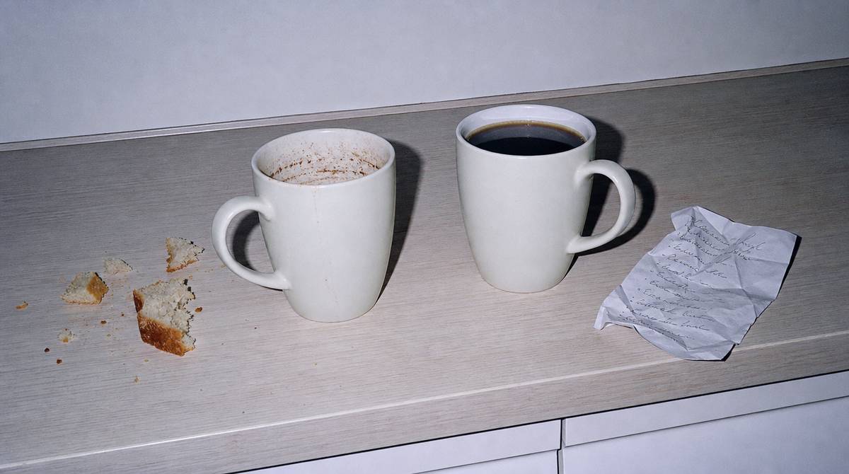 Dwa kubki kawy na kuchennym blacie o poranku, jeden wypity, drugi nietknięty