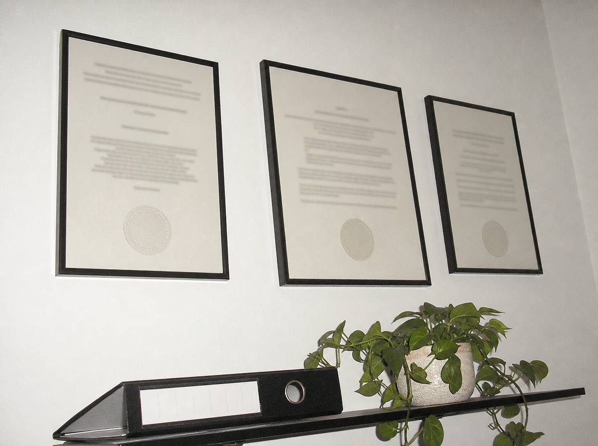 Oprawione dyplomy psychoterapeuty na ścianie gabinetu, potwierdzenie kwalifikacji przed pierwszą wizytą