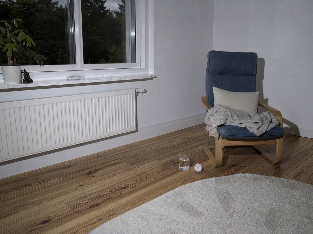 Fotel z kocem, szklanką wody i minutnikiem przygotowany do kilkuminutowych ćwiczeń oddechowych